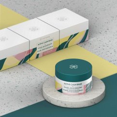 Tři bílé krabičky Harmony CBD balzámu na terrazzo povrchu s žlutými a zelenými geometrickými tvary v pozadí Tři bílé krabičky Harmony CBD balzámu na terrazzo povrchu s žlutými a zelenými geometrickými tvary v pozadí