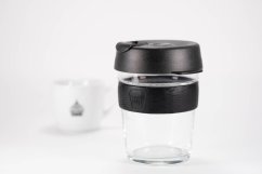 KeepCup Brew Black M 340 ml ze szklanym korpusem i czarną pokrywką, stylowy ekologiczny kubek o minimalistycznym designie na jasnym tle KeepCup Brew Black M 340 ml ze szklanym korpusem i czarną pokrywką, stylowy ekologiczny kubek o minimalistycznym designie na jasnym tle