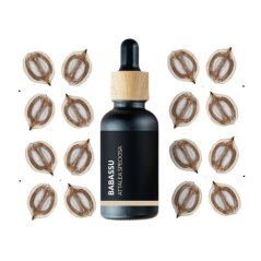 Zwarte glazen flesje met houten pipet in het midden, omringd door bruine babassu zaden op witte achtergrond, merk Pěstík Zwarte glazen flesje met houten pipet in het midden, omringd door bruine babassu zaden op witte achtergrond, merk Pěstík