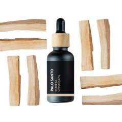 Crna staklena bočica s kapaljkom koja sadrži BIO eterično ulje Palo Santa, okružena svijetlim drvenim grančicama na bijeloj pozadini