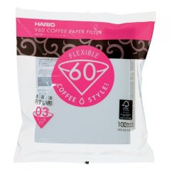 Boîte de filtres à papier Hario V60-03 en emballage blanc et rose avec logo rond, contenant 100 filtres pour préparer du café dans un dripper V60 Boîte de filtres à papier Hario V60-03 en emballage blanc et rose avec logo rond, contenant 100 filtres pour préparer du café dans un dripper V60