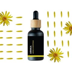 Zwarte glazen fles met houten pipet met BIO Arnica natuurlijke etherische olie, omringd door gele arnicabloemen en bloembladen