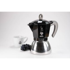 BIALETTI NEW MOKA INDUCTION musta kahvipannu valkoisella taustalla valkoisen kupin vieressä logolla ja mustilla marjoilla, tyylikäs muotoilu induktiolle