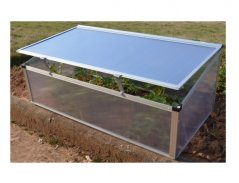 Minierre MINI SINGLE en polycarbonate transparent avec couvercle ouvert, plantes vertes à l'intérieur, dimensions 1,1x0,55x0,4h mètres, posé sur terre