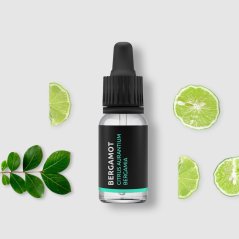 Bottiglia di vetro nero con contagocce contenente olio essenziale di bergamotto BIO, circondato da fettine fresche di lime e foglie verdi Bottiglia di vetro nero con contagocce contenente olio essenziale di bergamotto BIO, circondato da fettine fresche di lime e foglie verdi