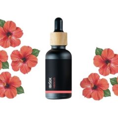 Zwarte fles met houten pipet bevat BIO hibiscus essentiële olie, omringd door rode hibiscusbloemen op witte achtergrond