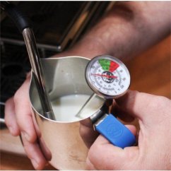Manos sosteniendo jarra de acero inoxidable con leche, con termómetro Rhinowares Short insertado con dial redondo y mango azul para medición precisa