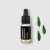 Petite bouteille en verre noir avec compte-gouttes contenant de l'huile essentielle bio citron eucalyptus, à côté de feuilles d'eucalyptus vertes sur fond blanc
